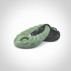 Hand carved New Zealand Jade ripples drop pendant. Made by Ana Krakosky for NZ Pacific in New Zealand Pounamu, jade. A beautiful light green jade ripples drop necklace with black adjustable cord.