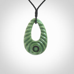 Hand carved New Zealand Jade ripples drop pendant. Made by Ana Krakosky for NZ Pacific in New Zealand Pounamu, jade. A beautiful light green jade ripples drop necklace with black adjustable cord.