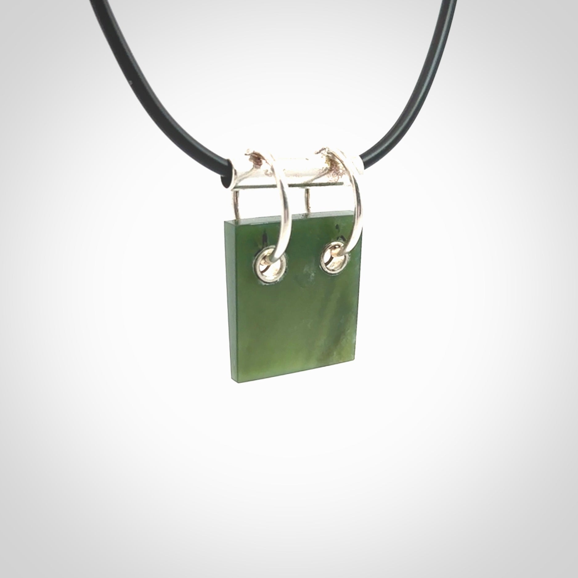 A photo of a New Zealand Jade rectangle drop pendant with sterling silver. This is a stylish statement piece - hand crafted here in New Zealand by Ana Krakosky. Unique Art to Wear. Gifts for all lovers of hand made Art to Wear.