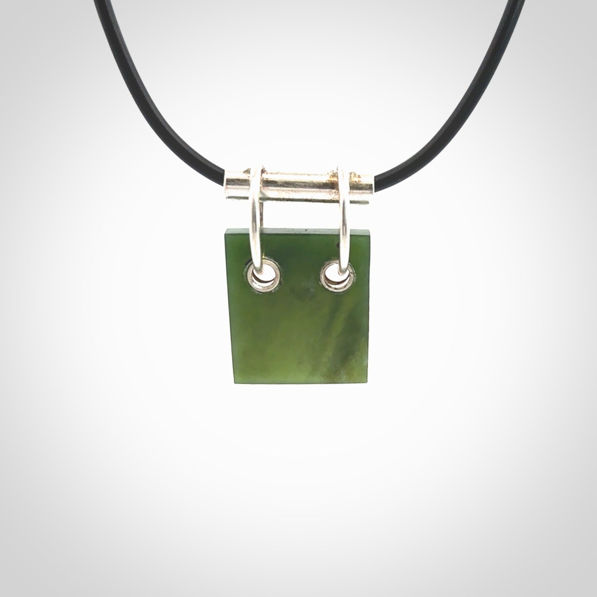 A photo of a New Zealand Jade rectangle drop pendant with sterling silver. This is a stylish statement piece - hand crafted here in New Zealand by Ana Krakosky. Unique Art to Wear. Gifts for all lovers of hand made Art to Wear.