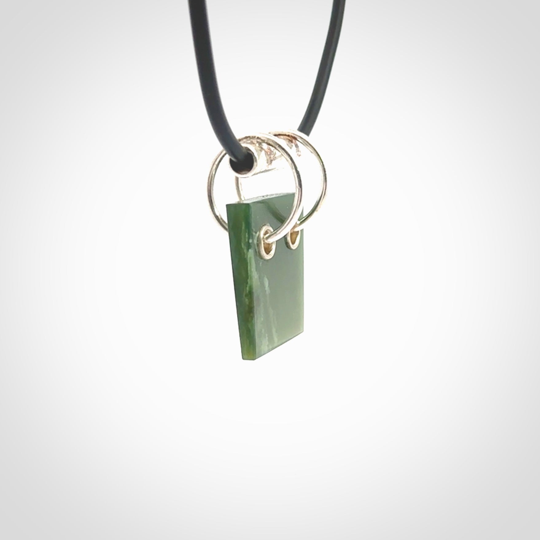 A photo of a New Zealand Jade rectangle drop pendant with sterling silver. This is a stylish statement piece - hand crafted here in New Zealand by Ana Krakosky. Unique Art to Wear. Gifts for all lovers of hand made Art to Wear.