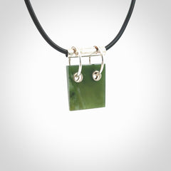 A photo of a New Zealand Jade rectangle drop pendant with sterling silver. This is a stylish statement piece - hand crafted here in New Zealand by Ana Krakosky. Unique Art to Wear. Gifts for all lovers of hand made Art to Wear.