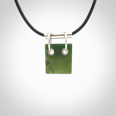 A photo of a New Zealand Jade rectangle drop pendant with sterling silver. This is a stylish statement piece - hand crafted here in New Zealand by Ana Krakosky. Unique Art to Wear. Gifts for all lovers of hand made Art to Wear.