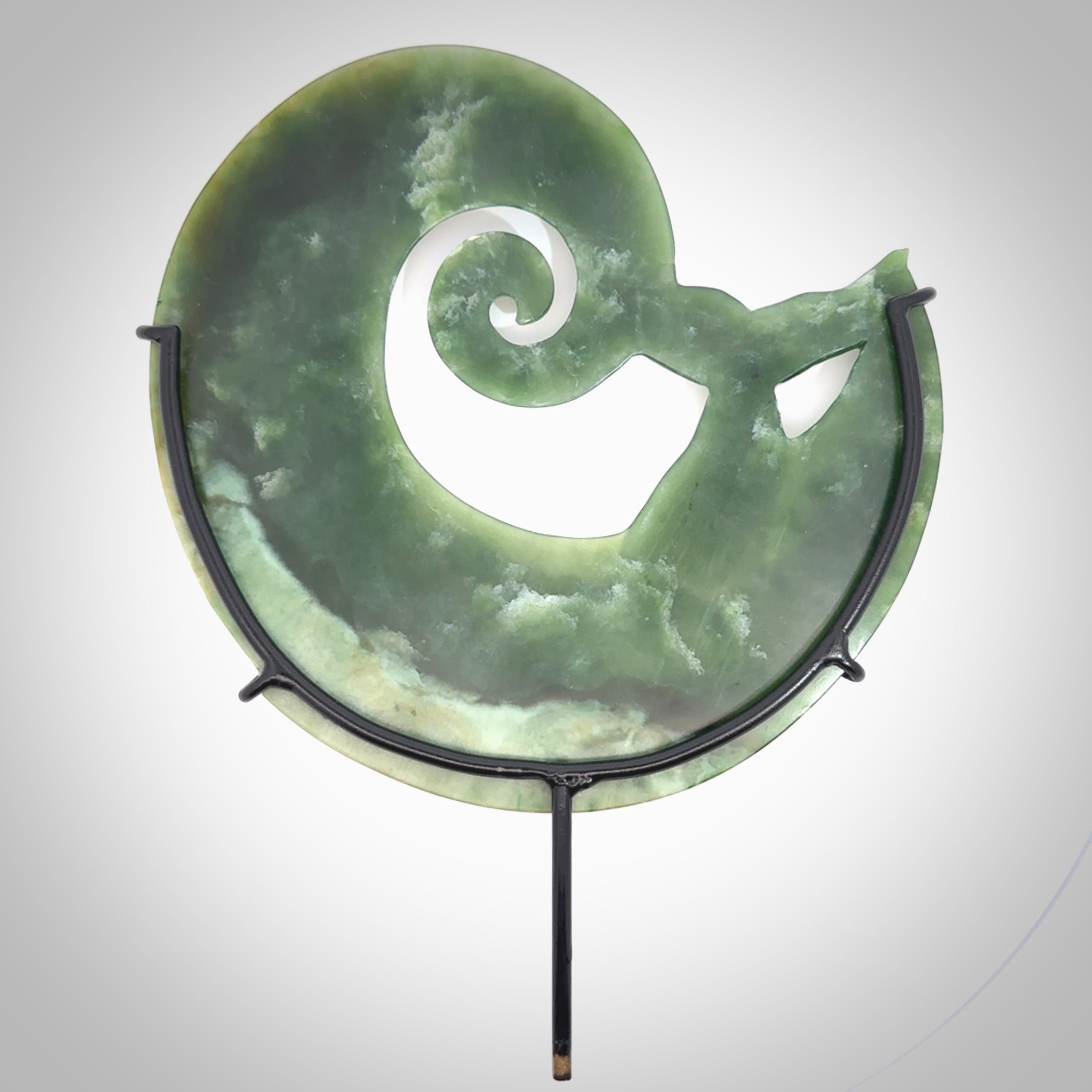 A photo of a New Zealand Jade whale tail in a wave sculpture with Rata Burr stand. This is a statement piece - hand crafted here in New Zealand by Ana Krakosky. Unique Art to display. Gifts for all lovers of hand made sculptures.