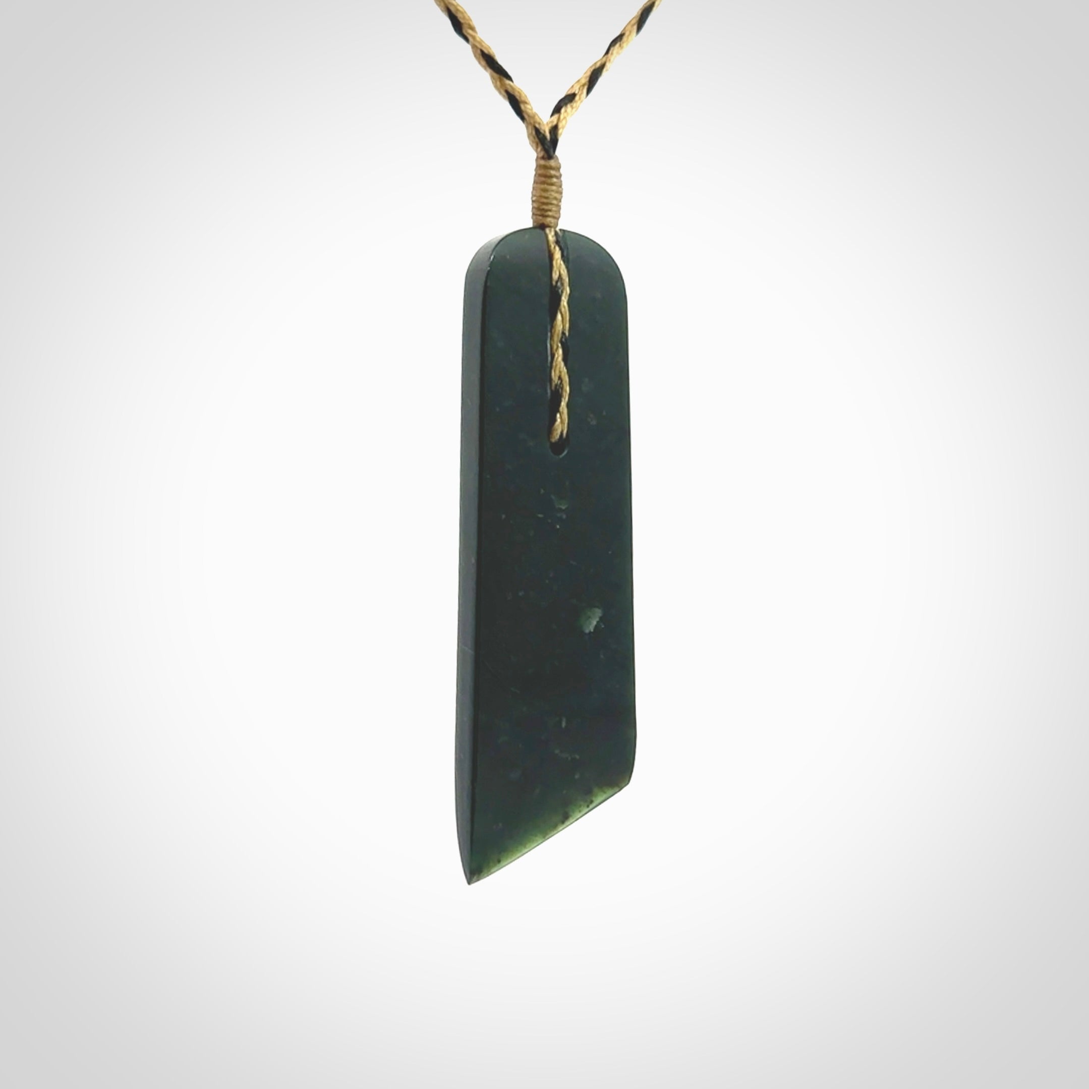 Large New Zealand Tangiwai Pounamu Toki pendant. Hand carved from a lovely piece of local New Zealand Tangiwai Stone. The quality of the workmanship and design is outstanding - this is a piece you will want to wear all the time. We have suspended this from an adjustable 3-plait tan/black cord.