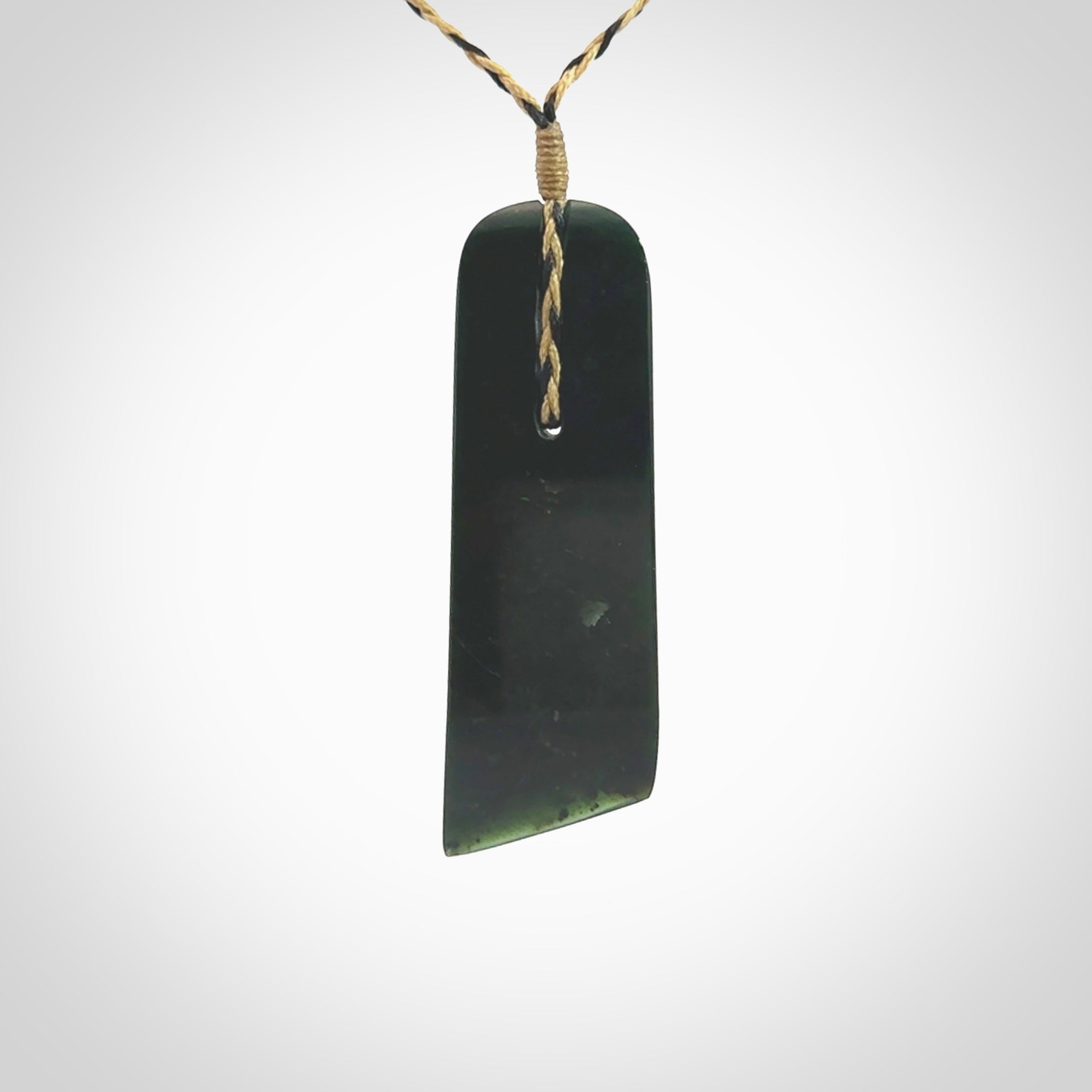 Large New Zealand Tangiwai Pounamu Toki pendant. Hand carved from a lovely piece of local New Zealand Tangiwai Stone. The quality of the workmanship and design is outstanding - this is a piece you will want to wear all the time. We have suspended this from an adjustable 3-plait tan/black cord.