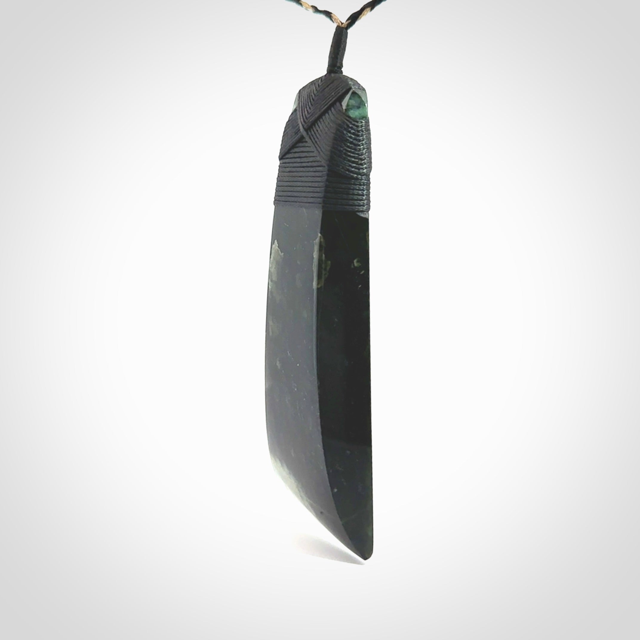 Large Jade Toki pendant. Hand carved from a lovely piece of local New Zealand Jade. The quality of the workmanship and design is outstanding - this is a piece you will want to wear all the time. We have suspended this from an adjustable 3-plait tan/black cord and black binding.