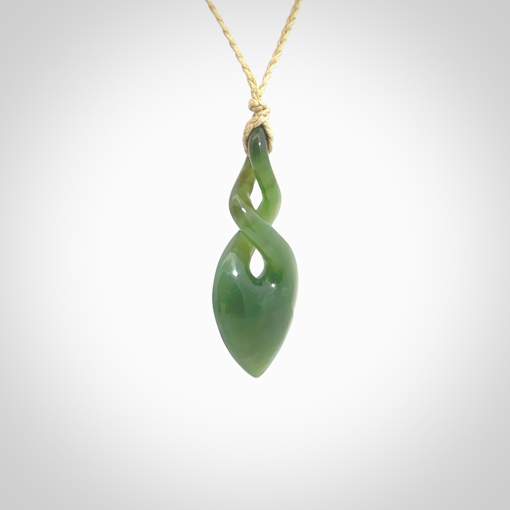 Hand carved New Zealand jade twist pendant. Carved in New Zealand by NZ Pacific. Unique double twist jewellery for sale online. Provided with an adjustable cord.