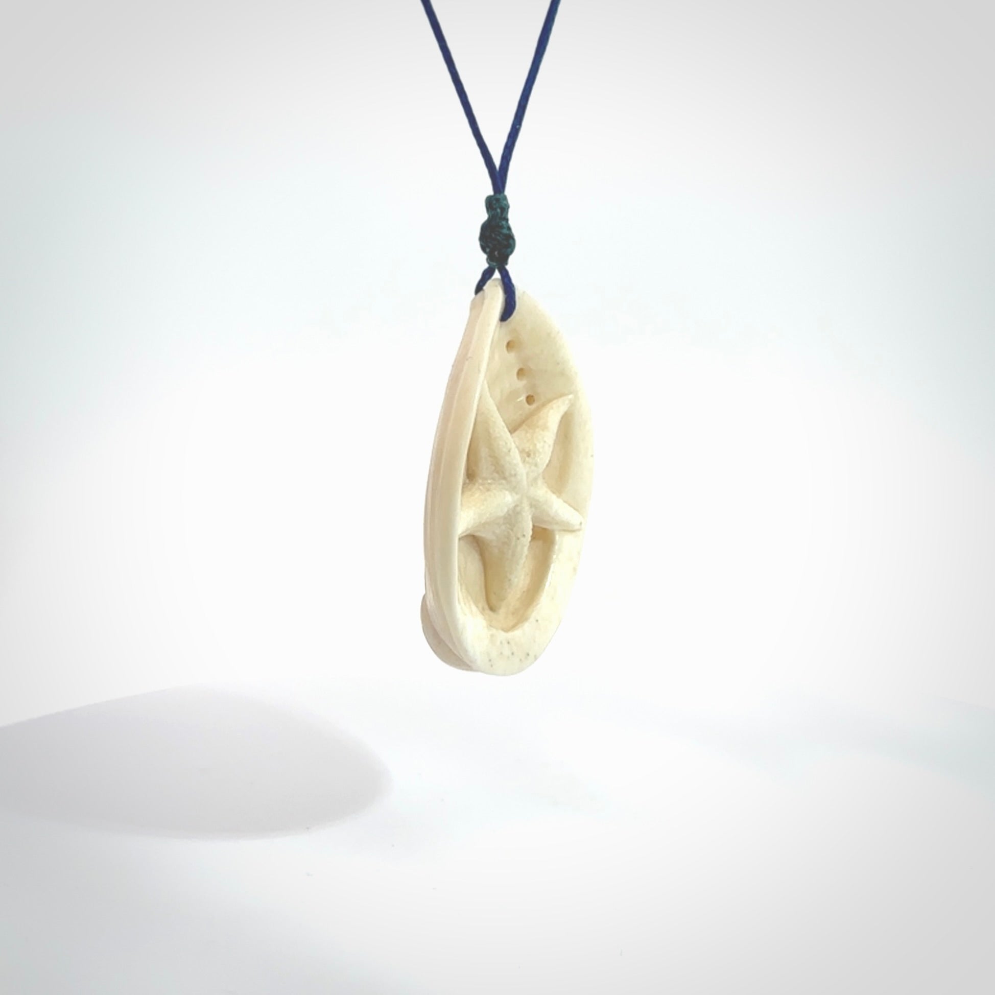 Hand carved bone paua shell with starfish inside pendant. Made from Bone in New Zealand. Unique Pāua Shell necklace hand made from bone with starfish carving inside the shell. Made by master bone carver Fumio Noguchi. Spectacular collectable work of art, made to wear. One only pendant, delivered to you with express courier on a blue adjustable cord.