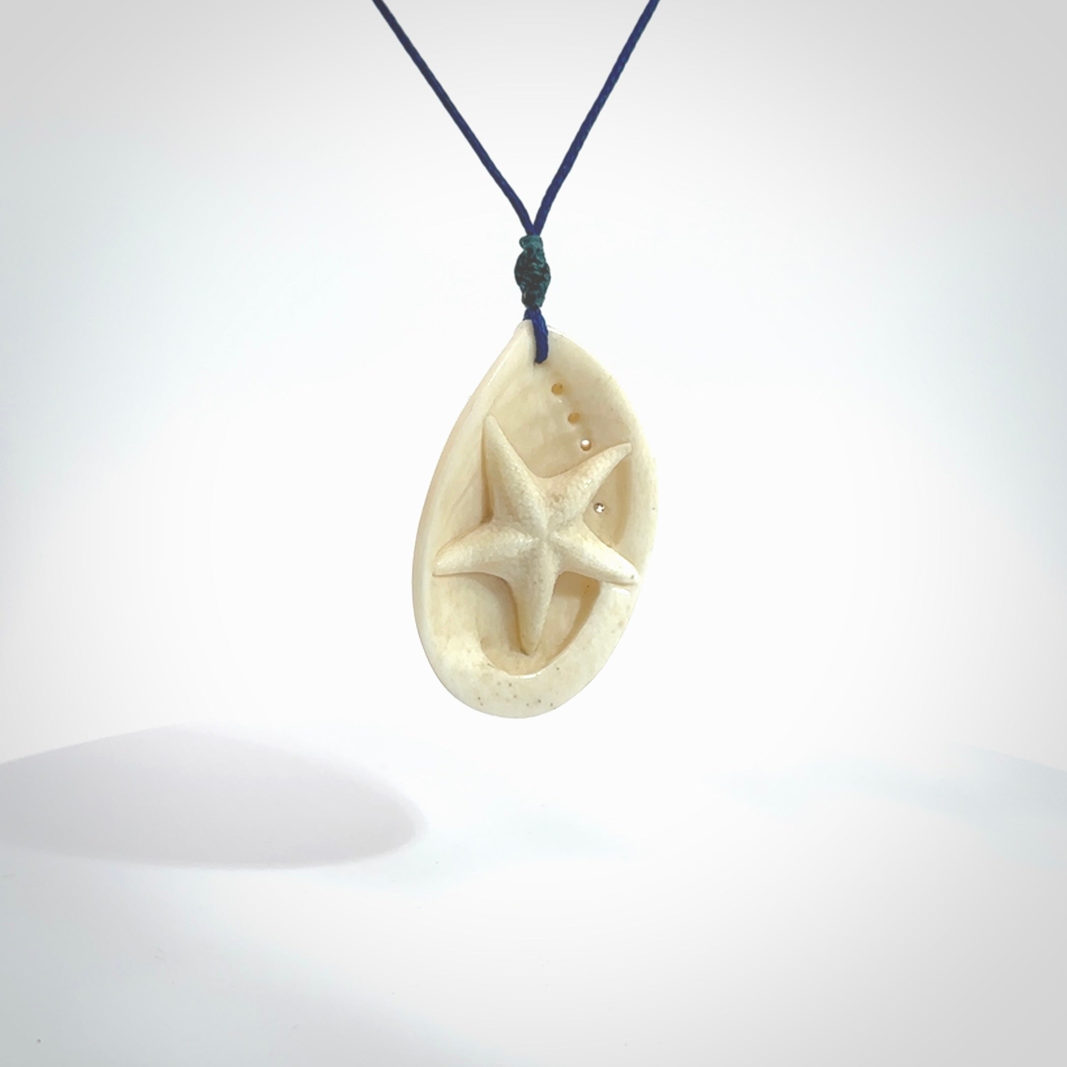 Hand carved bone paua shell with starfish inside pendant. Made from Bone in New Zealand. Unique Pāua Shell necklace hand made from bone with starfish carving inside the shell. Made by master bone carver Fumio Noguchi. Spectacular collectable work of art, made to wear. One only pendant, delivered to you with express courier on a blue adjustable cord.