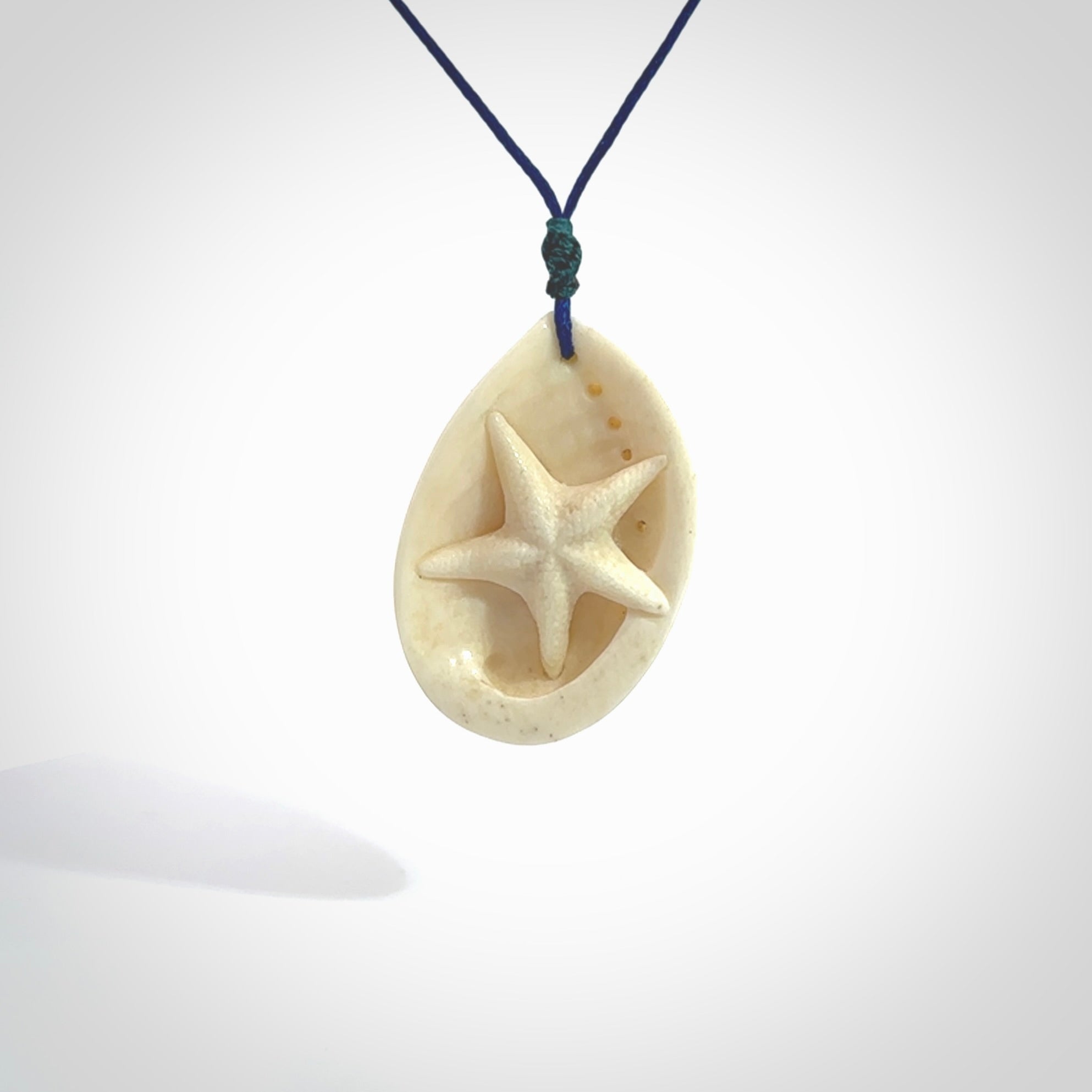 Hand carved bone paua shell with starfish inside pendant. Made from Bone in New Zealand. Unique Pāua Shell necklace hand made from bone with starfish carving inside the shell. Made by master bone carver Fumio Noguchi. Spectacular collectable work of art, made to wear. One only pendant, delivered to you with express courier on a blue adjustable cord.