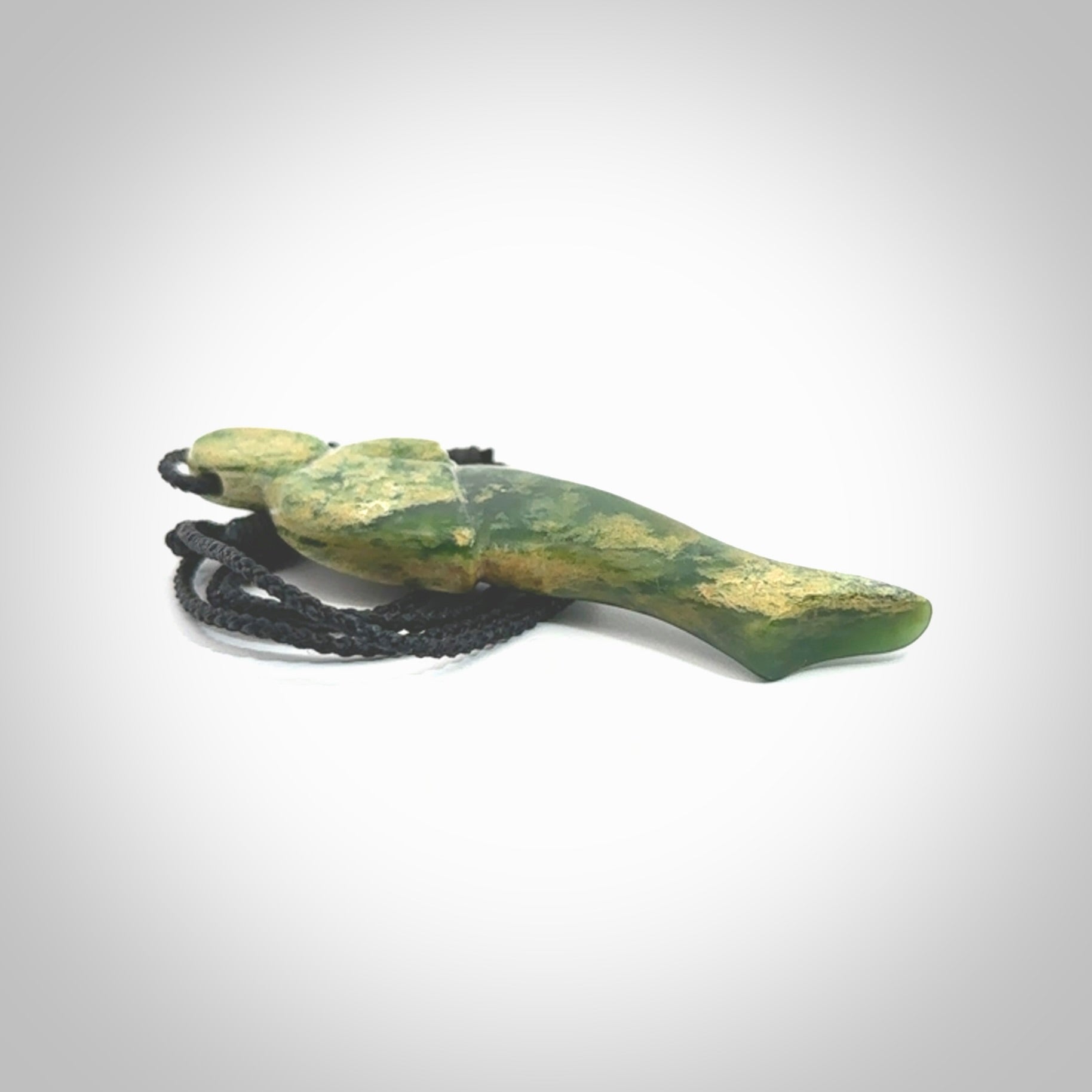 Hand carved New Zealand Flower Jade woman drop pendant. Made by Ana Krakosky for NZ Pacific in New Zealand Pounamu, jade. A beautiful green and light orange jade figure of a woman, drop necklace with black adjustable cord.