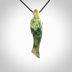 Hand carved New Zealand Flower Jade woman drop pendant. Made by Ana Krakosky for NZ Pacific in New Zealand Pounamu, jade. A beautiful green and light orange jade figure of a woman, drop necklace with black adjustable cord.