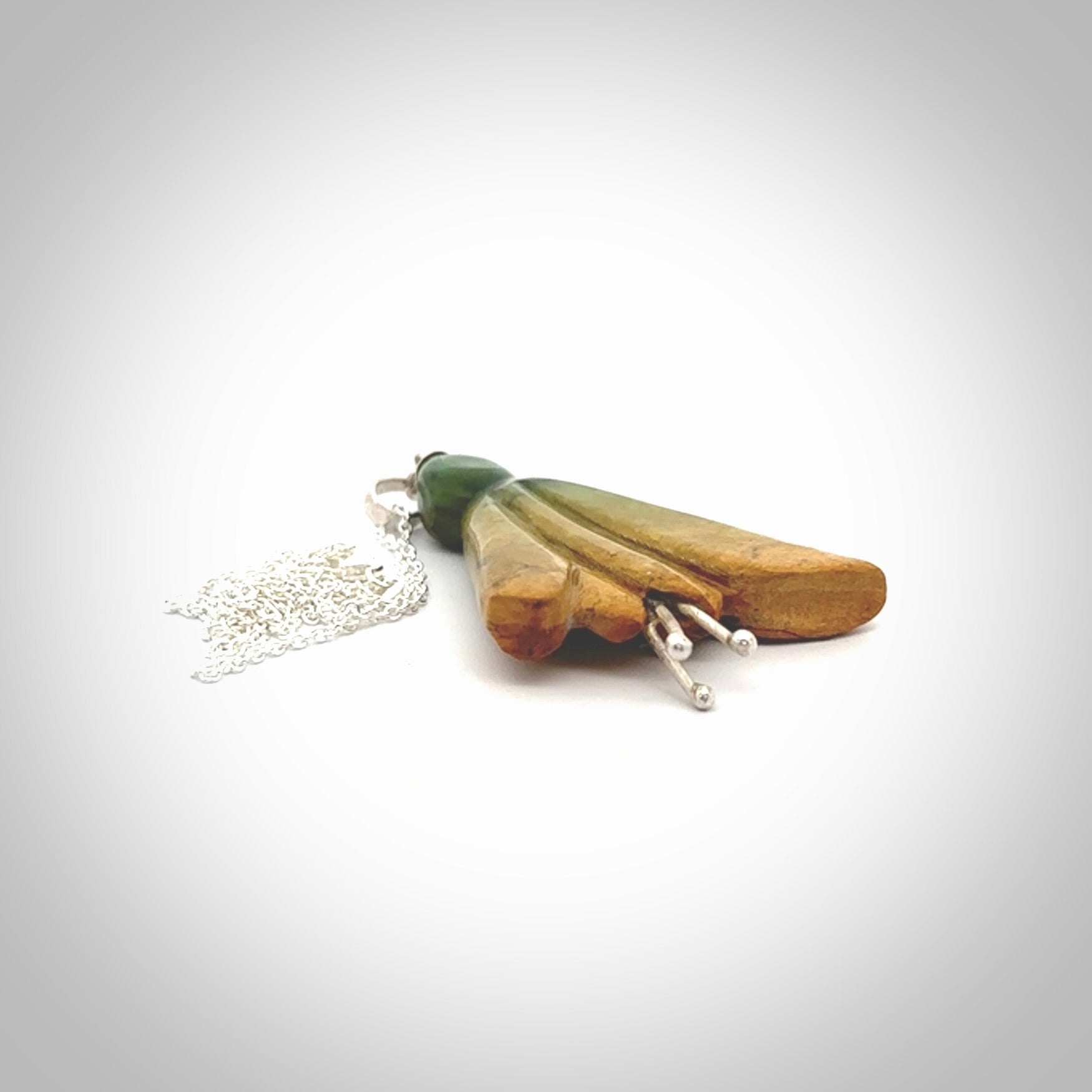 This kowhai flower drop pendant is beautifully hand made with gorgeous flair. It is fashionable and perfect for a women with style. Hand carved from a gorgeous piece of New Zealand Flower jade and sterling silver - this is an elegant and beautiful piece of art to wear.