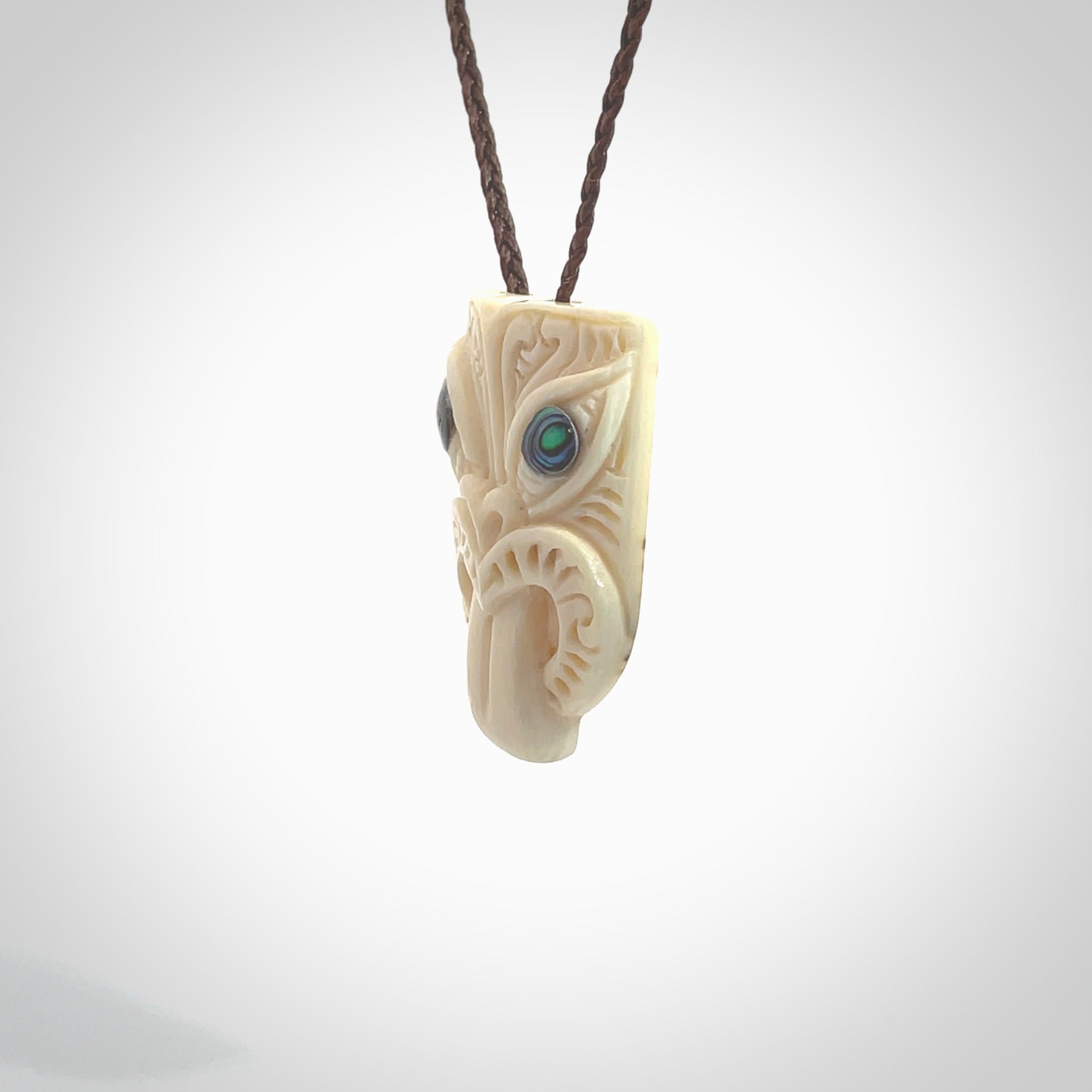 Hand carved Wheku pendant. Carved from woolly mammoth Tusk by NZ Pacific. Hand crafted Mammoth tusk jewellery for sale online. Provided with an adjustable cord and packaged in woven kete pouch