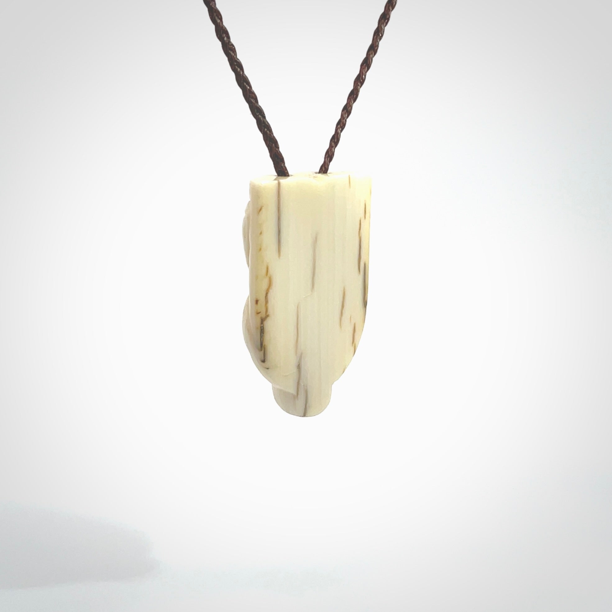 Hand carved Wheku pendant. Carved from woolly mammoth Tusk by NZ Pacific. Hand crafted Mammoth tusk jewellery for sale online. Provided with an adjustable cord and packaged in woven kete pouch