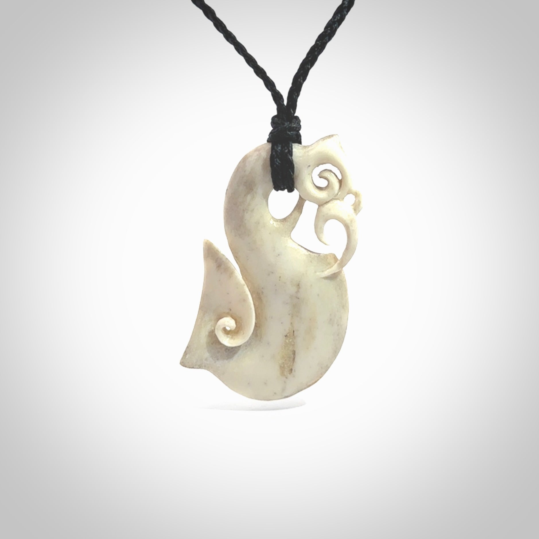 Hand made deer antler manaia pendant. Hand carved by NZ Pacific. Manaia carved from deer antler pendant for sale online. Delivered to you on an adjustable black cord and packaged in a woven kete pouch.