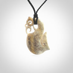 Hand made deer antler manaia pendant. Hand carved by NZ Pacific. Manaia carved from deer antler pendant for sale online. Delivered to you on an adjustable black cord and packaged in a woven kete pouch.