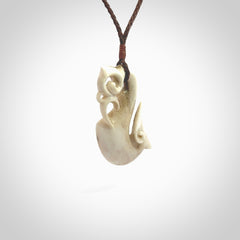 Hand made deer antler manaia pendant. Hand carved by NZ Pacific. Manaia carved from deer antler pendant for sale online. Delivered to you on an adjustable brown cord and packaged in a woven kete pouch.