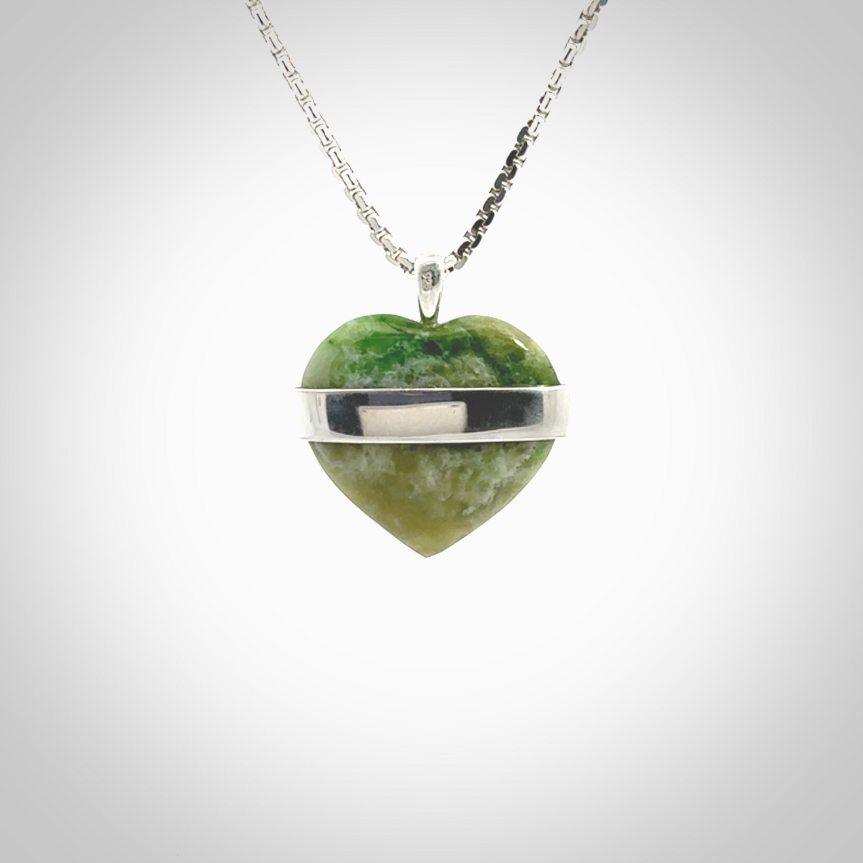 Hand crafted New Zealand jade love heart necklace. This piece has  a sterling silver love written across its' body. This necklace is provided with a sterling silver chain.