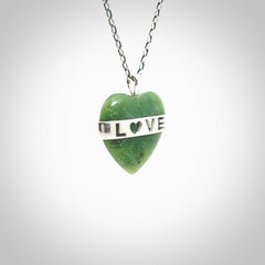 Hand crafted New Zealand jade love heart necklace. This piece has  a sterling silver love written across its' body. This necklace is provided with a sterling silver chain.