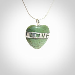 Hand crafted New Zealand jade love heart necklace. This piece has  a sterling silver love written across its' body. This necklace is provided with a sterling silver chain.