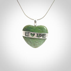 Hand crafted New Zealand jade love heart necklace. This piece has  a sterling silver love written across its' body. This necklace is provided with a sterling silver chain.