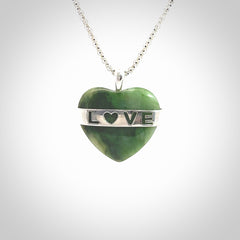 Hand crafted New Zealand jade love heart necklace. This piece has  a sterling silver love written across its' body. This necklace is provided with a sterling silver chain.