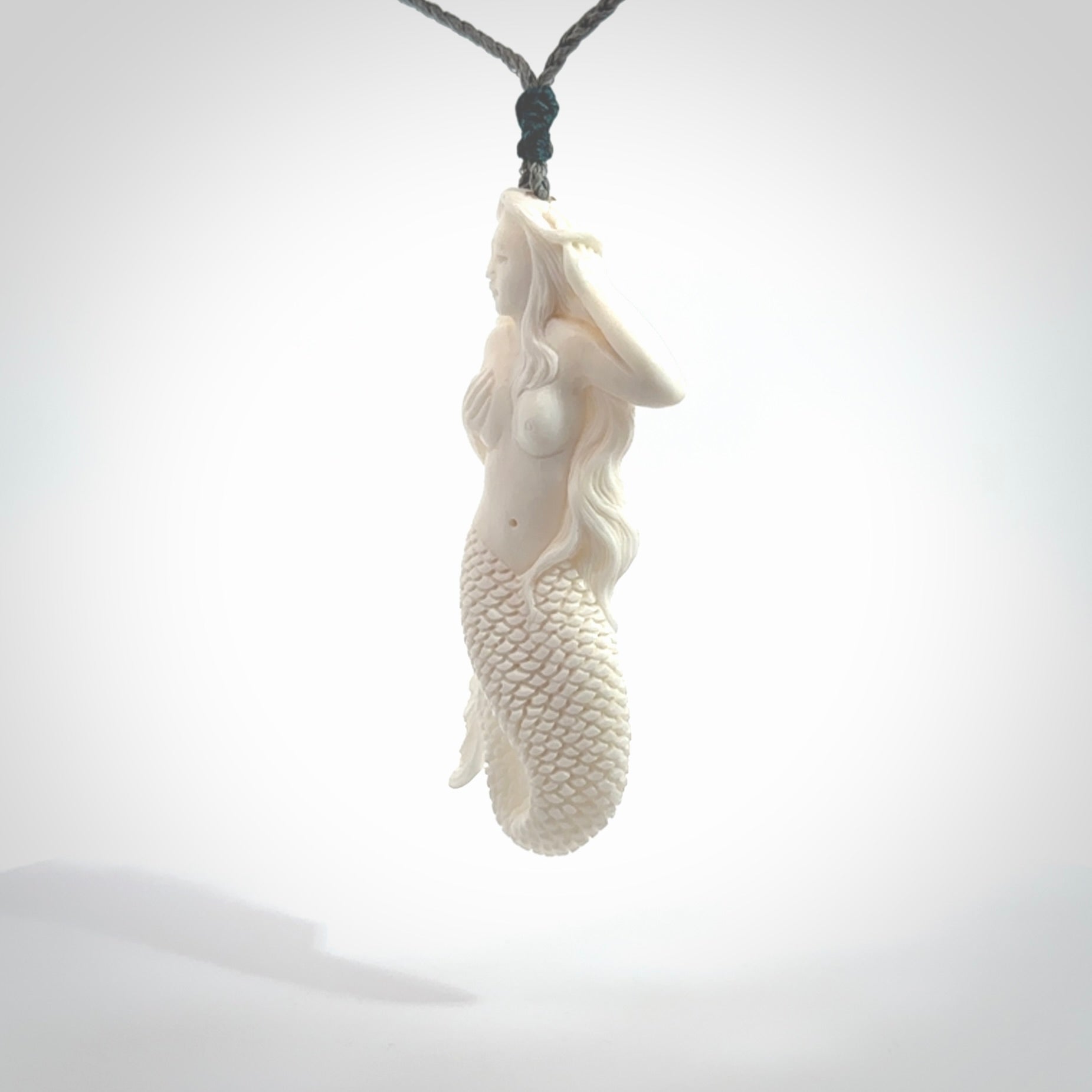 Hand carved large natural bone mermaid pendant. Hand made from real bone. Art to wear. Provided with an adjustable length grey cord and packaged in a woven kete pouch. Bone mermaid necklace.