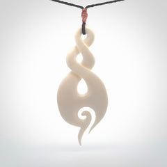 A hand carved large bone twist with koru. A beautiful large double twist pendant carved from bone for NZ Pacific. This is a true piece of wearable art and is provided with an adjustable plum coloured cord.