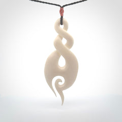 A hand carved large bone twist with koru. A beautiful large double twist pendant carved from bone for NZ Pacific. This is a true piece of wearable art and is provided with an adjustable plum coloured cord.