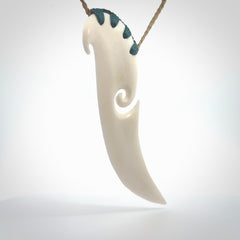 A hand carved large bone drop pendant with koru. A beautiful large drop pendant carved from bone for NZ Pacific. This is a true piece of wearable art and is provided with an adjustable tan coloured cord.