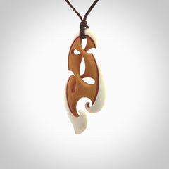 A hand carved bone contemporary, intricate pendant. The cord is a brown colour and is a adjustable in length. A medium-large sized hand made contemporary necklace by New Zealand artist Kerry Thompson. Kerry has stained parts of the bone which really add to the dimension of this pendant. One off work of art to wear.