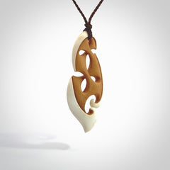 A hand carved bone contemporary, intricate pendant. The cord is a brown colour and is a adjustable in length. A medium-large sized hand made contemporary necklace by New Zealand artist Kerry Thompson. Kerry has stained parts of the bone which really add to the dimension of this pendant. One off work of art to wear.