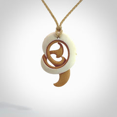 A hand carved bone contemporary, intricate pendant. The cord is a oat colour and is a adjustable in length. A medium sized hand made contemporary necklace by New Zealand artist Kerry Thompson. Kerry has stained parts of the bone which really add to the dimension of this pendant. One off work of art to wear.