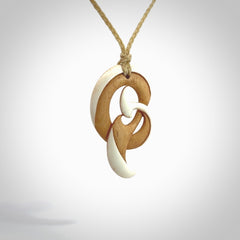 A hand carved bone contemporary, intricate pendant. The cord is a oat colour and is a adjustable in length. A medium sized hand made contemporary necklace by New Zealand artist Kerry Thompson. Kerry has stained parts of the bone which really add to the dimension of this pendant. One off work of art to wear.