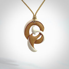 A hand carved bone contemporary, intricate pendant. The cord is a oat colour and is a adjustable in length. A medium sized hand made contemporary necklace by New Zealand artist Kerry Thompson. Kerry has stained parts of the bone which really add to the dimension of this pendant. One off work of art to wear.