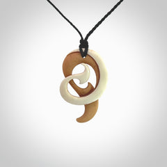 A hand carved bone contemporary, intricate pendant. The cord is a black colour and is a adjustable in length. A medium sized hand made contemporary necklace by New Zealand artist Kerry Thompson. Kerry has stained parts of the bone which really add to the dimension of this pendant. One off work of art to wear.