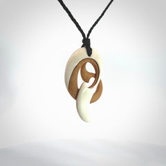 A hand carved bone contemporary, intricate pendant. The cord is a black colour and is a adjustable in length. A medium sized hand made contemporary necklace by New Zealand artist Kerry Thompson. Kerry has stained parts of the bone which really add to the dimension of this pendant. One off work of art to wear.