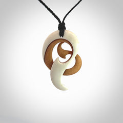 A hand carved bone contemporary, intricate pendant. The cord is a black colour and is a adjustable in length. A medium sized hand made contemporary necklace by New Zealand artist Kerry Thompson. Kerry has stained parts of the bone which really add to the dimension of this pendant. One off work of art to wear.