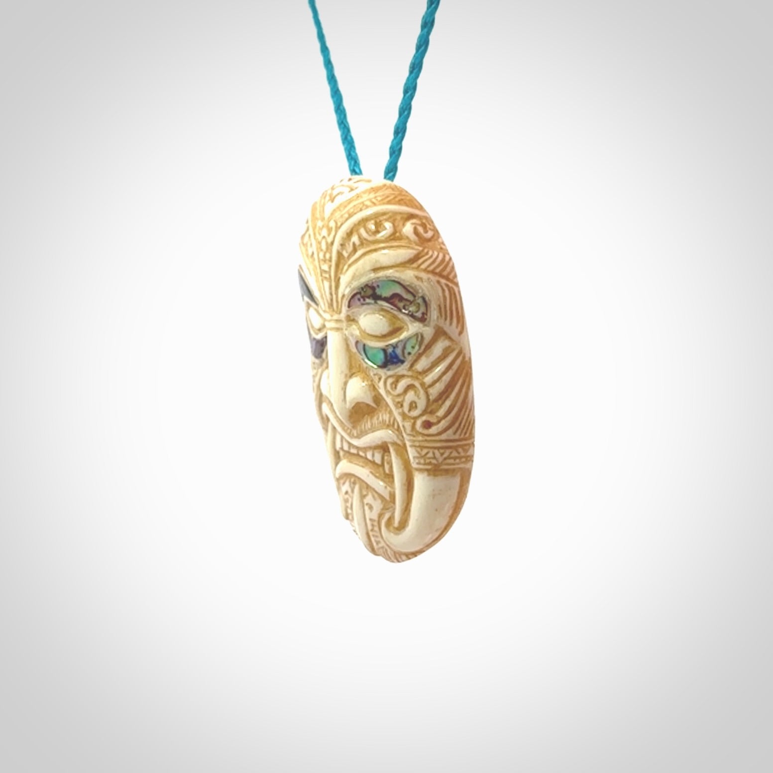 This picture shows a hand carved face pendant. It is carved from bone with paua shell and although a medium piece, it is a wonderful, delicate piece of jewellery. The cord is hand plaited and adjustable so that you can position the pendant where it suits you best. Delivery is free worldwide.