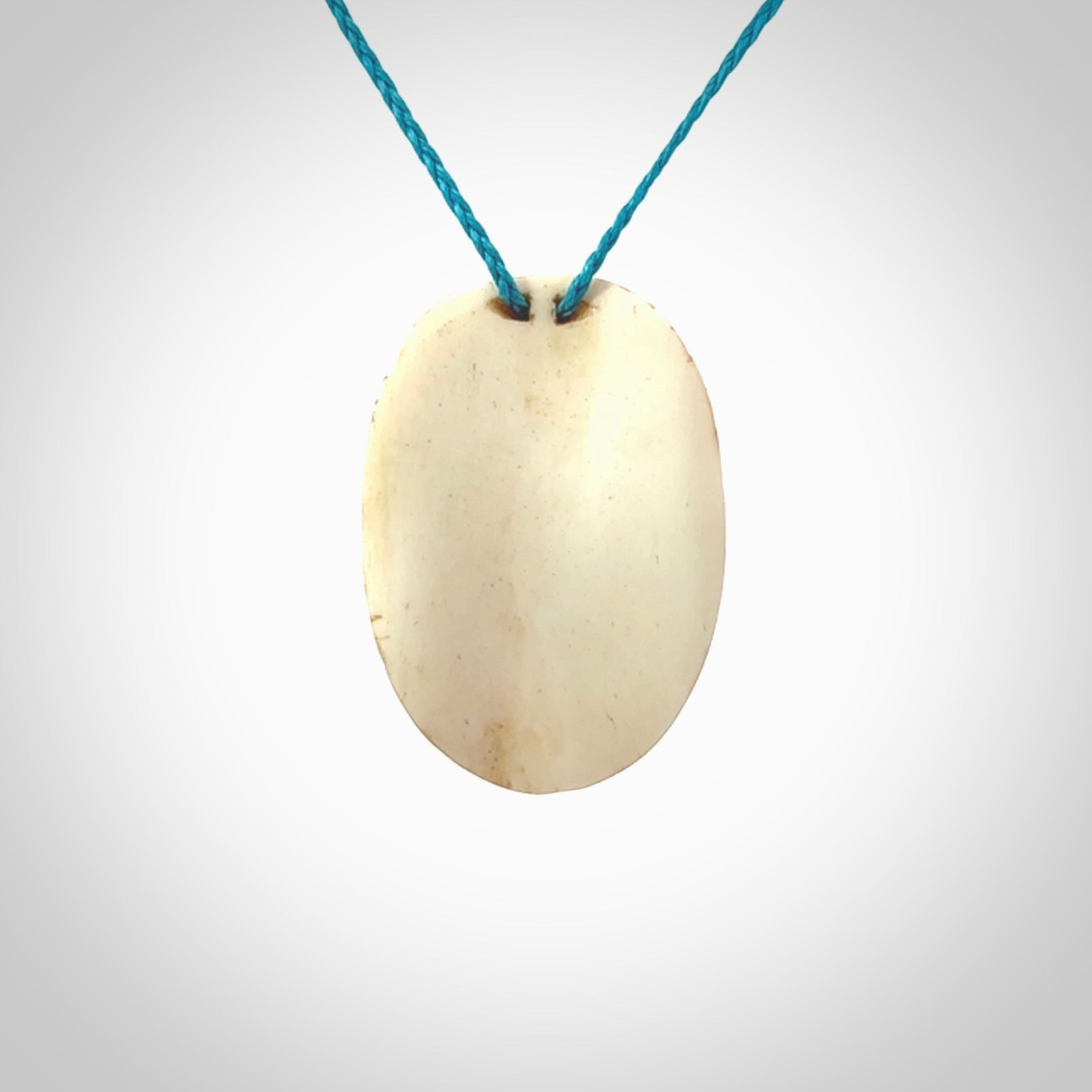 This picture shows a hand carved face pendant. It is carved from bone with paua shell and although a medium piece, it is a wonderful, delicate piece of jewellery. The cord is hand plaited and adjustable so that you can position the pendant where it suits you best. Delivery is free worldwide.