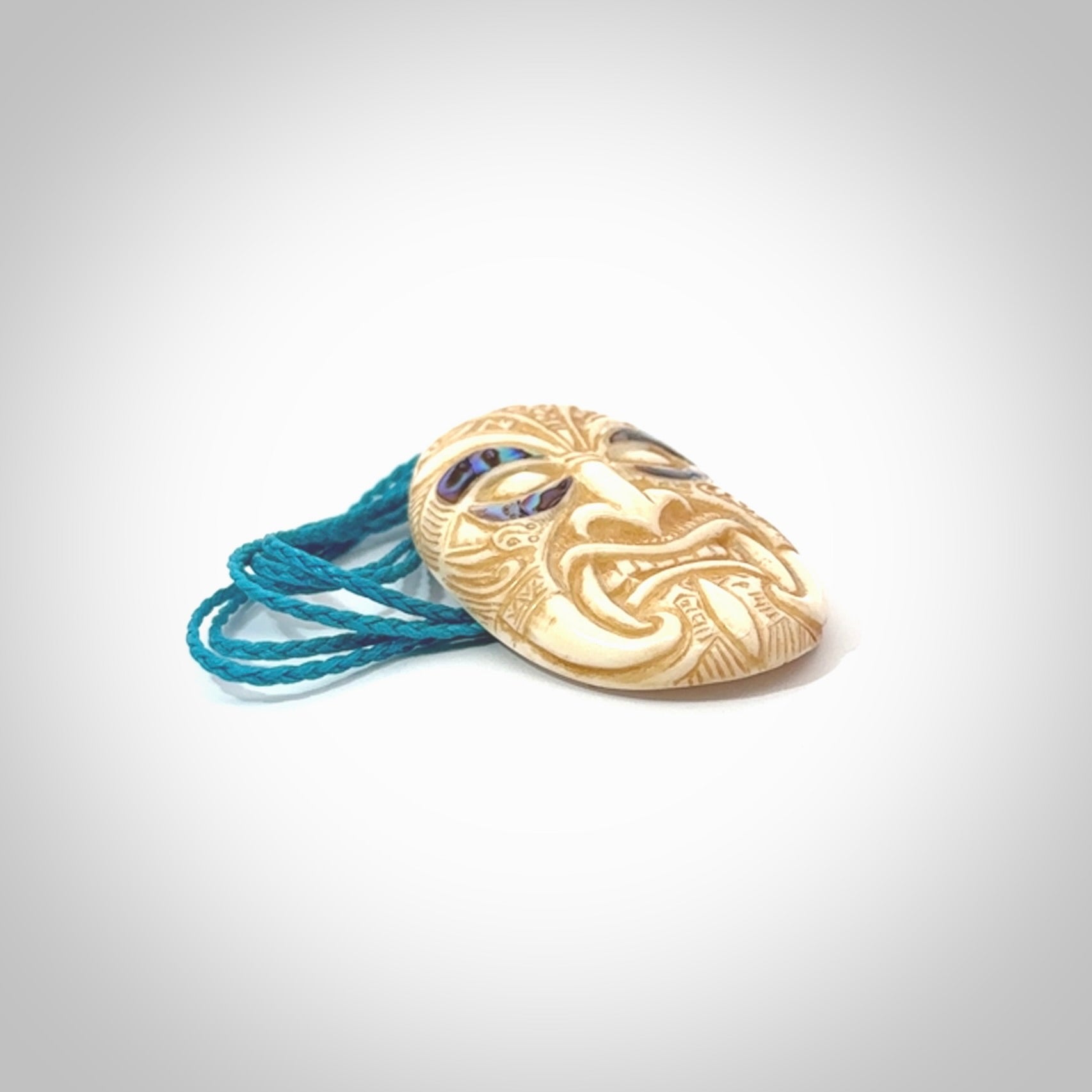 This picture shows a hand carved face pendant. It is carved from bone with paua shell and although a medium piece, it is a wonderful, delicate piece of jewellery. The cord is hand plaited and adjustable so that you can position the pendant where it suits you best. Delivery is free worldwide.