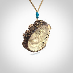 A hand carved baby in the womb pendant made from a piece of deer antler crown. This is a work of art carved in deer antler, bone. We deliver this pendant to you on a plaited tan cord. Delivery with Express Courier is included in the price.