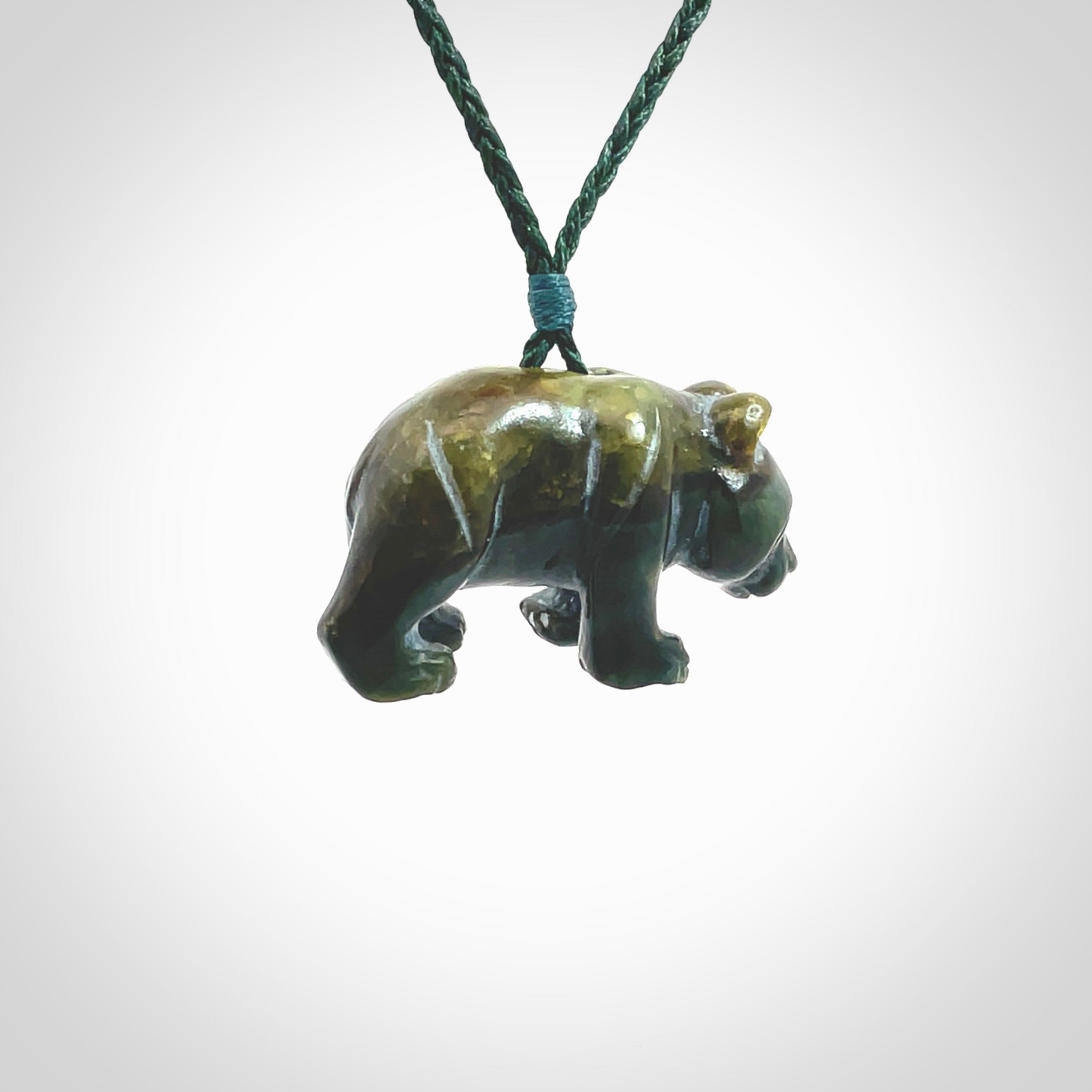 This picture shows a pendant that we designed in New Zealand jade. It is a little green bear that has a walking stance and is carved in detail. A really attractive and eye-catching piece of handmade jewellery. The cord is hand plaited braid in manuka green and the length can be adjusted.