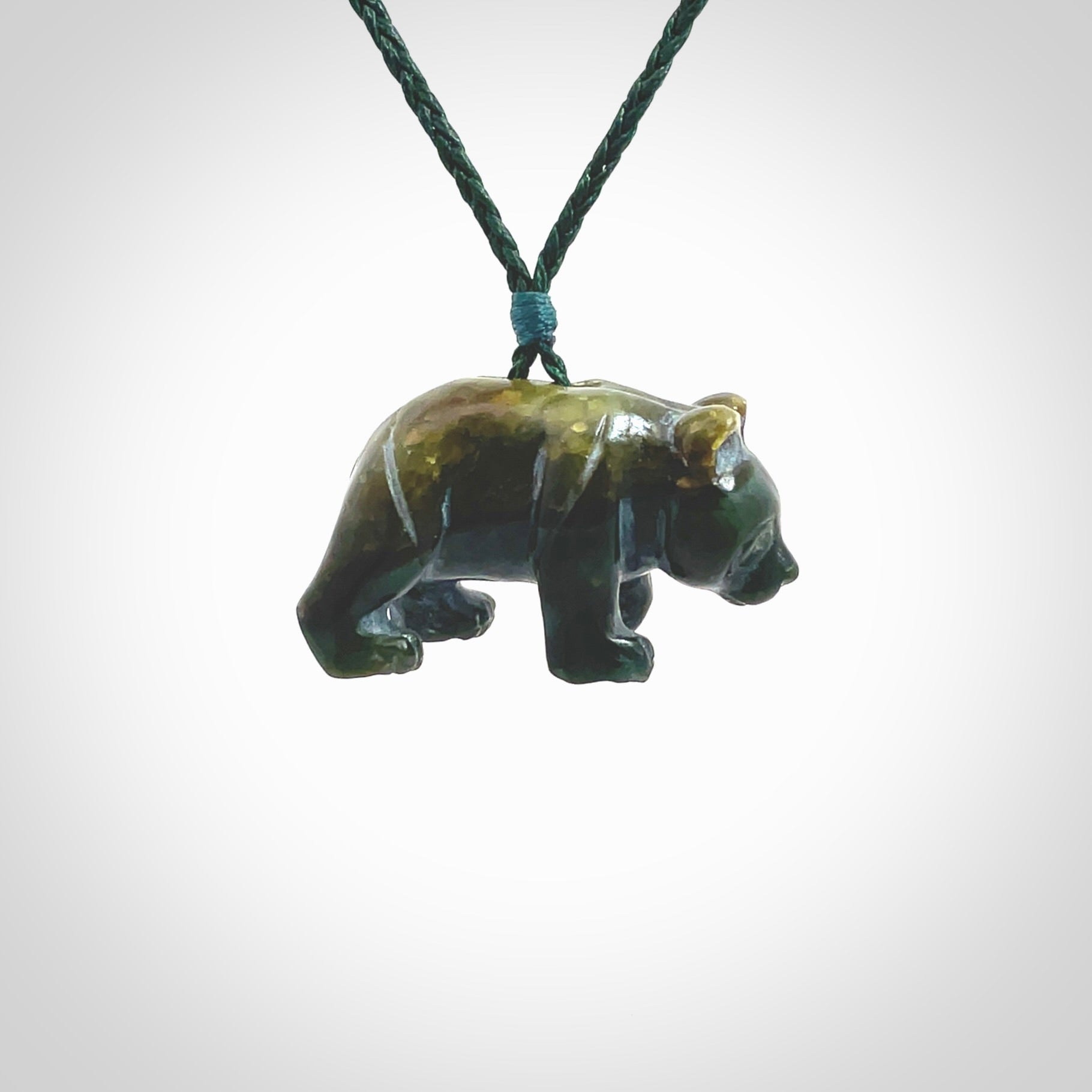 This picture shows a pendant that we designed in New Zealand jade. It is a little green bear that has a walking stance and is carved in detail. A really attractive and eye-catching piece of handmade jewellery. The cord is hand plaited braid in manuka green and the length can be adjusted.