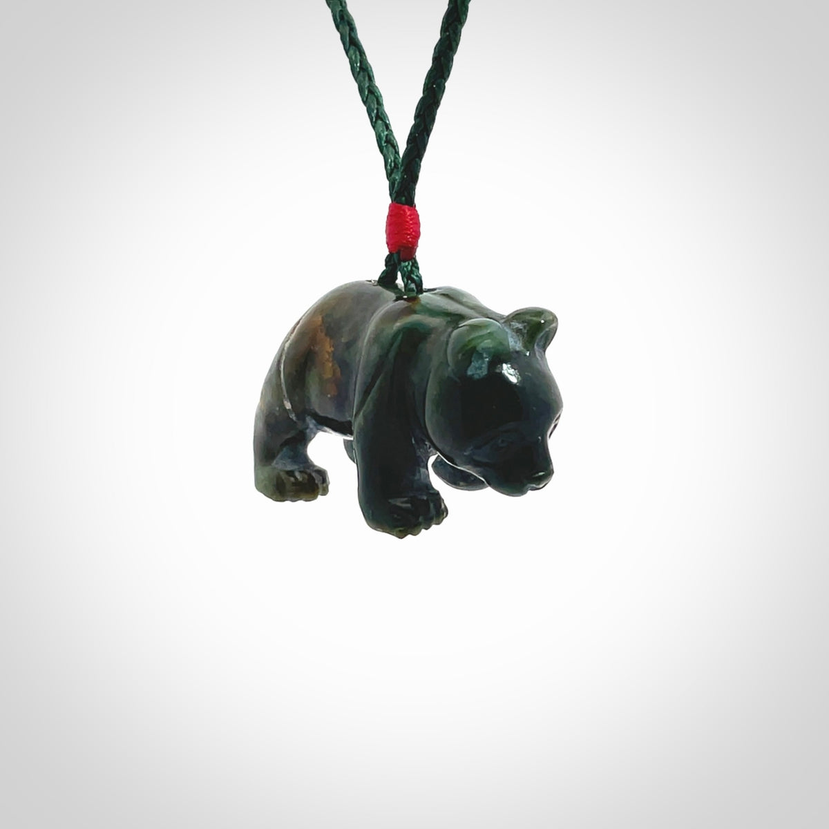 This picture shows a pendant that we designed in New Zealand jade. It is a little green bear that has a walking stance and is carved in detail. A really attractive and eye-catching piece of handmade jewellery. The cord is hand plaited braid in manuka green and the length can be adjusted.