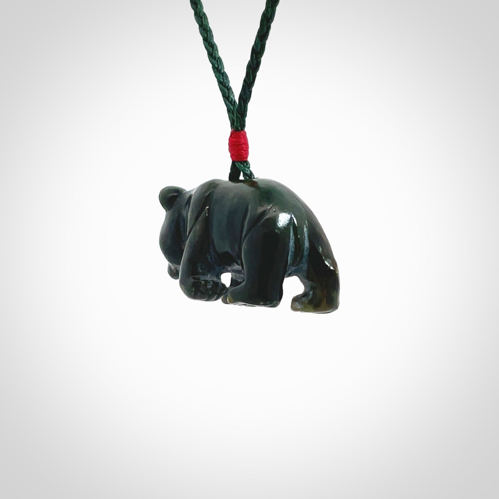 This picture shows a pendant that we designed in New Zealand jade. It is a little green bear that has a walking stance and is carved in detail. A really attractive and eye-catching piece of handmade jewellery. The cord is hand plaited braid in manuka green and the length can be adjusted.