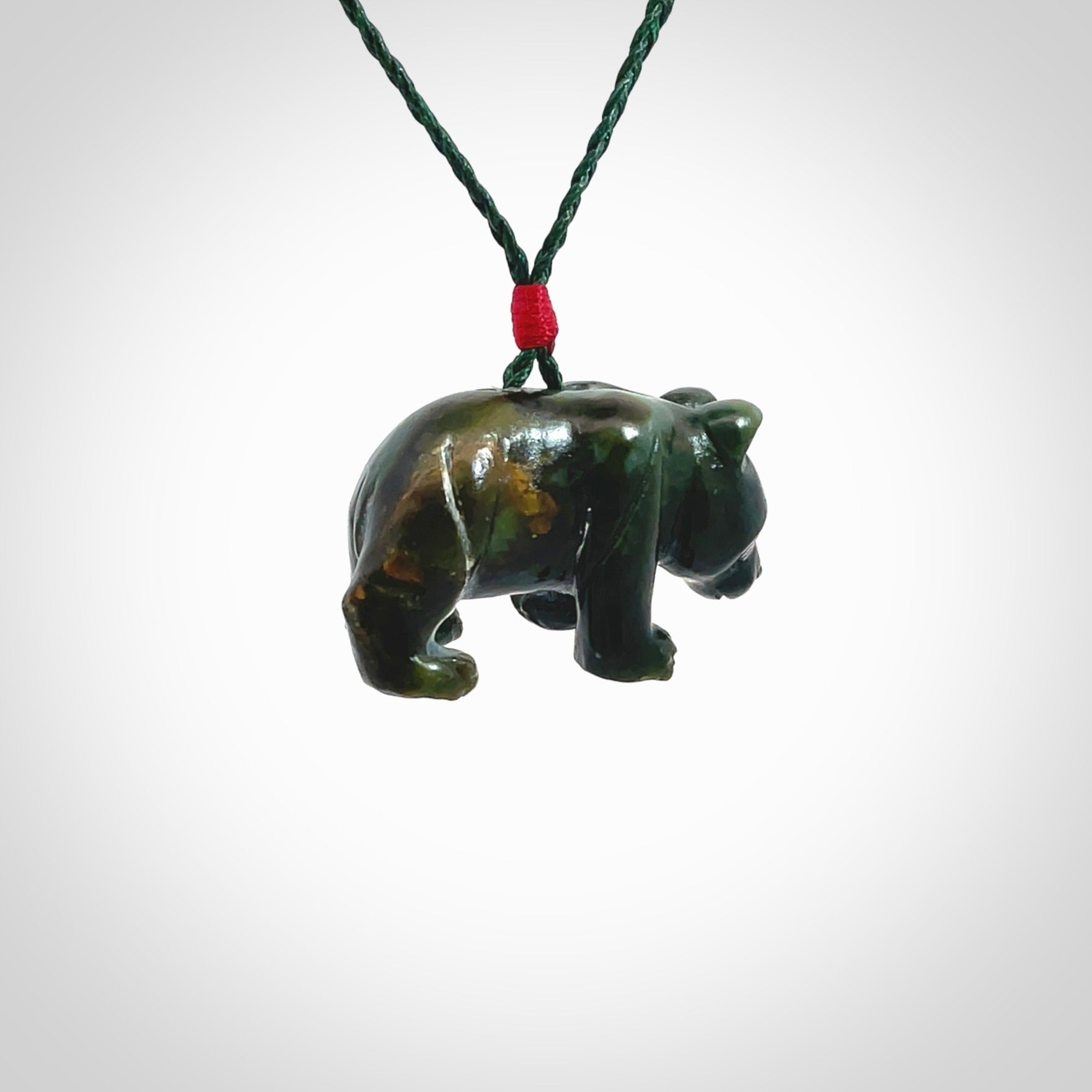 This picture shows a pendant that we designed in New Zealand jade. It is a little green bear that has a walking stance and is carved in detail. A really attractive and eye-catching piece of handmade jewellery. The cord is hand plaited braid in manuka green and the length can be adjusted.