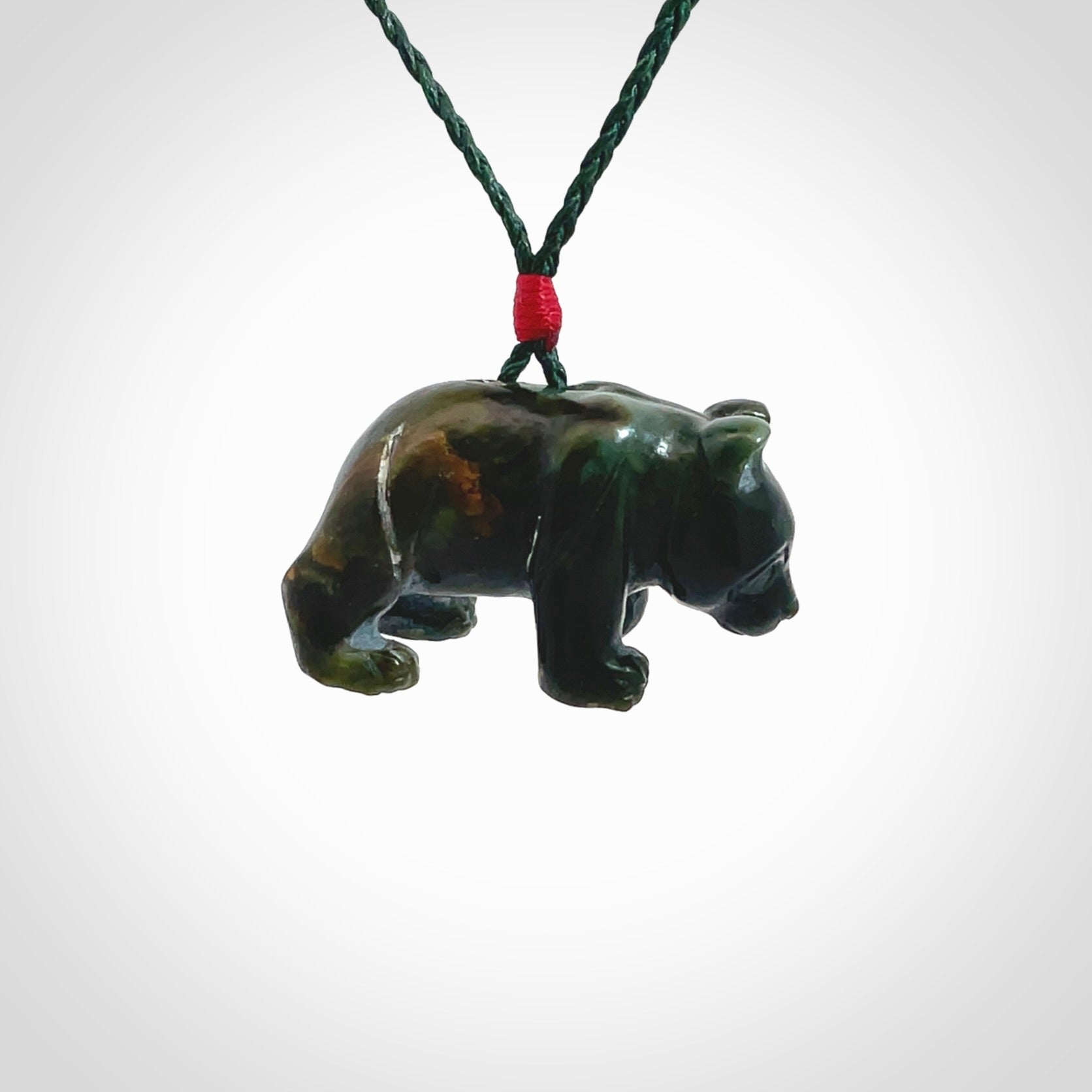 This picture shows a pendant that we designed in New Zealand jade. It is a little green bear that has a walking stance and is carved in detail. A really attractive and eye-catching piece of handmade jewellery. The cord is hand plaited braid in manuka green and the length can be adjusted.